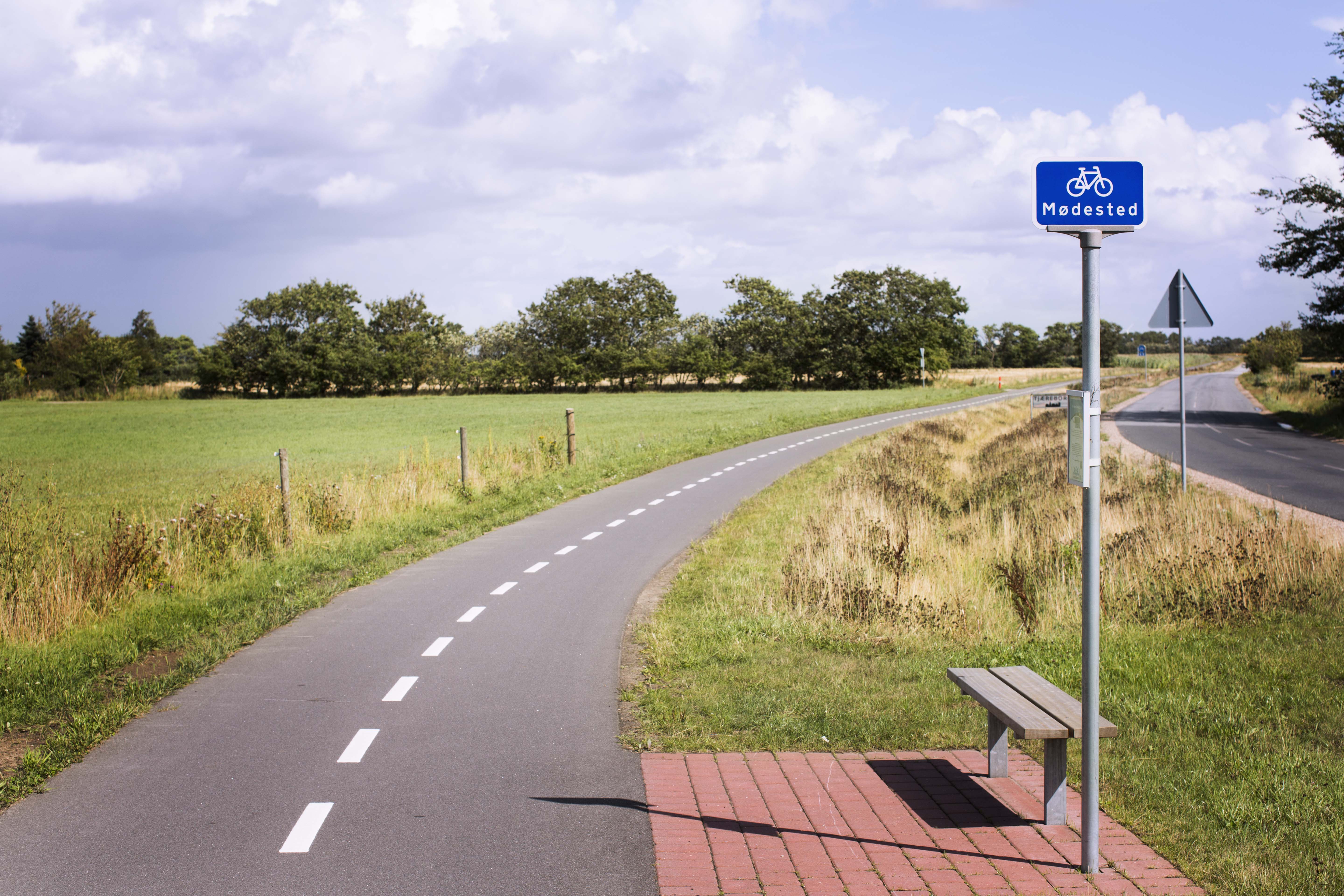 Dobbeltrettet cykelsti langs en mindre vej med marker på begge sider